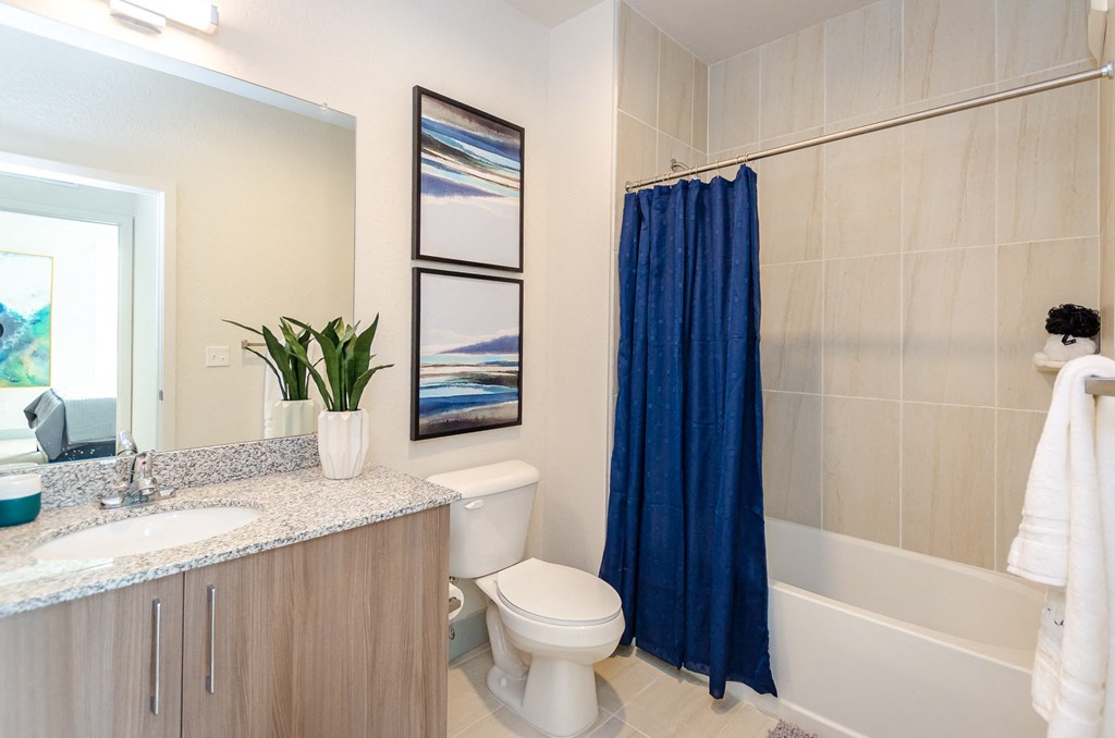 a bathroom with a blue shower curtain and a toilet and a sink at Lofts at South Lake, Clermont, 34711
