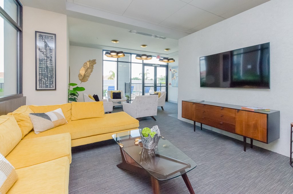 a living room with a yellow couch and a television at Lofts at South Lake, Clermont, 34711