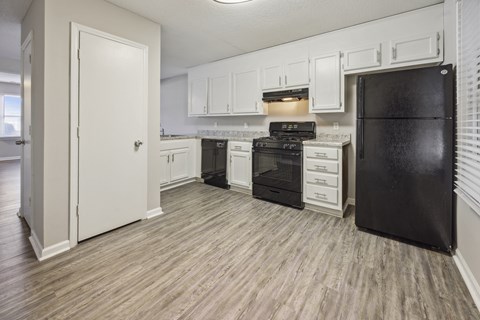 a kitchen with white cabinets and a black refrigerator