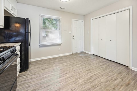 an empty kitchen and living room with a stove and refrigerator