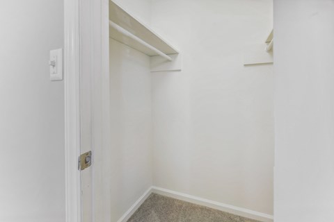 an empty room with white walls and a door to a closet