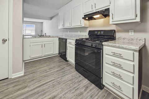 a kitchen with white cabinets and a black stove