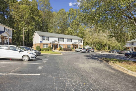 A parking lot with cars and a building in the background.