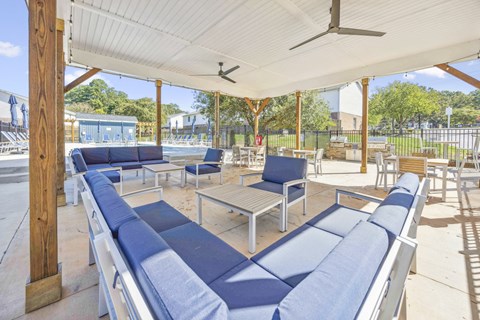 A covered outdoor seating area with blue cushioned benches.