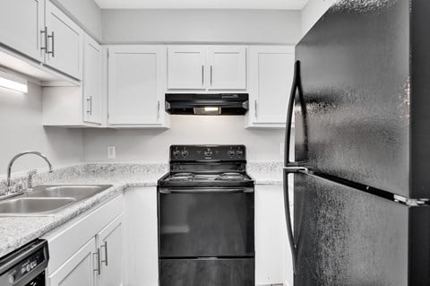 a kitchen with white cabinets and a black stove and refrigerator