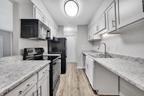 a kitchen with marble counter tops and white cabinets
