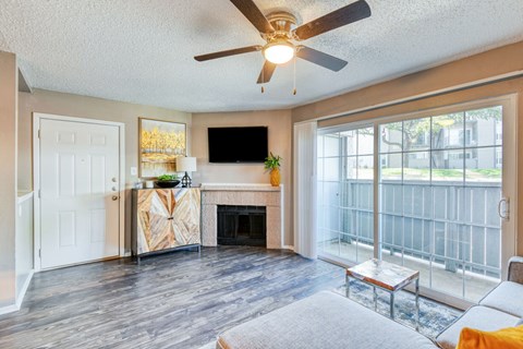 A living room with a fireplace and a flat screen TV mounted on the wall.