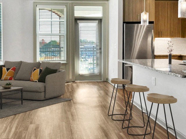 a living room with a couch and a kitchen with stools