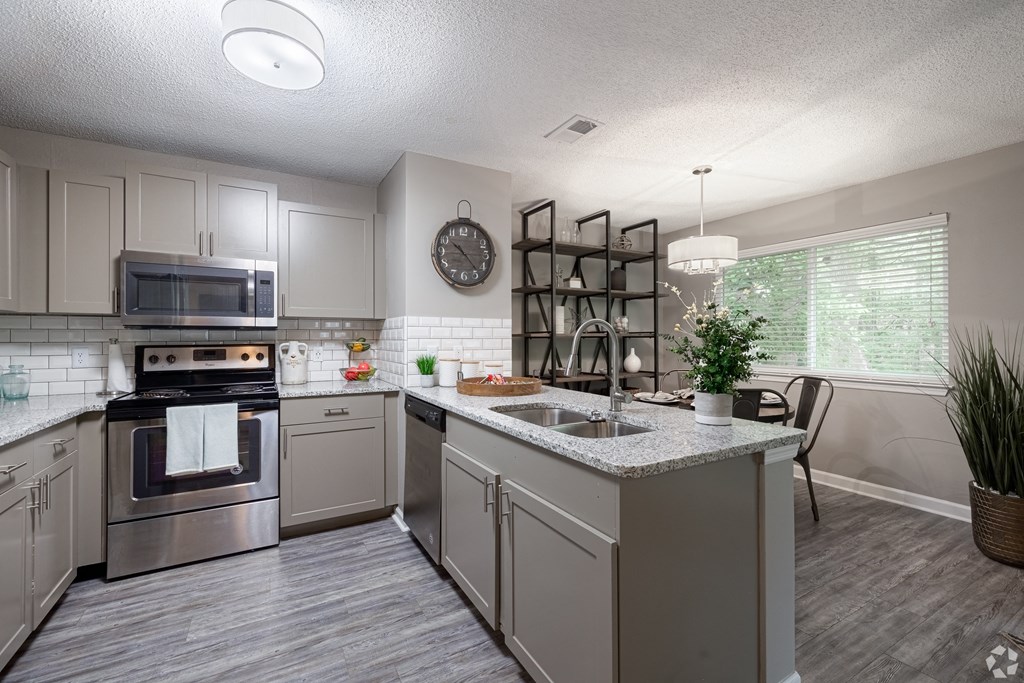an open kitchen with stainless steel appliances and granite counter tops