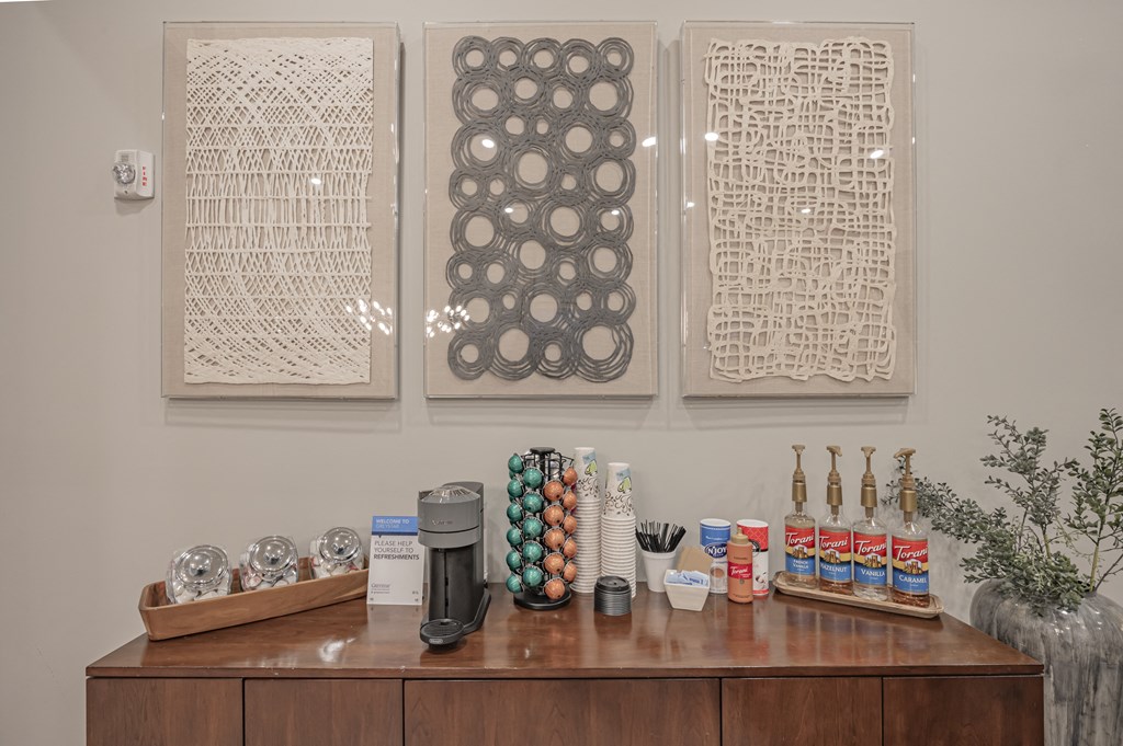 three pieces of artwork hanging on the wall above a counter with coffee and other items at Century HomePlace, Prattville, 36066