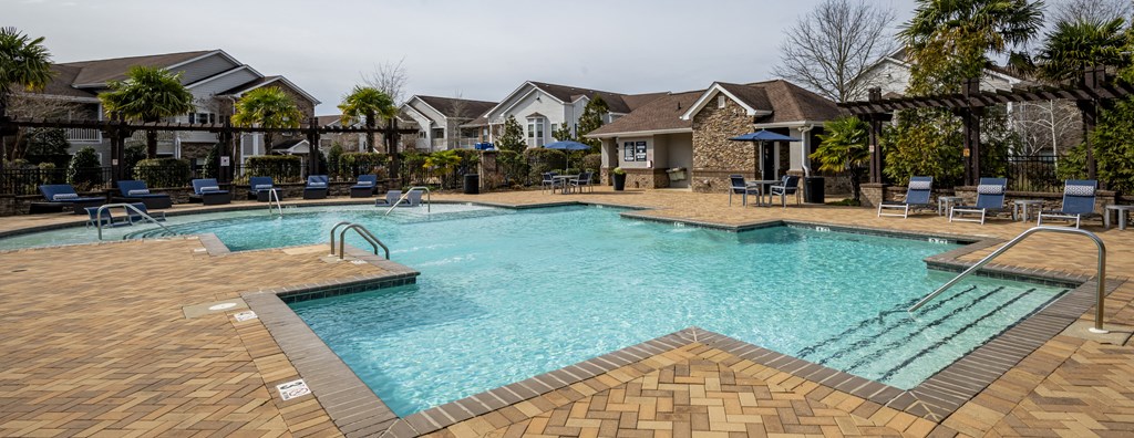 our apartments have a large swimming pool with chairs at Century HomePlace, Prattville, AL