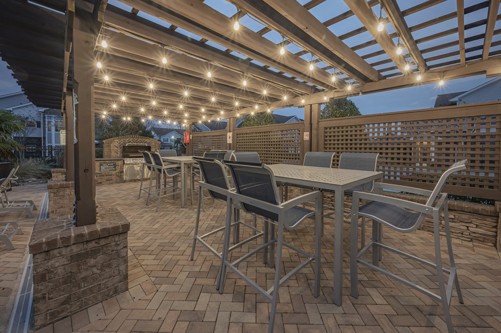 a patio with tables and chairs under a pergola at Century HomePlace, Prattville, AL