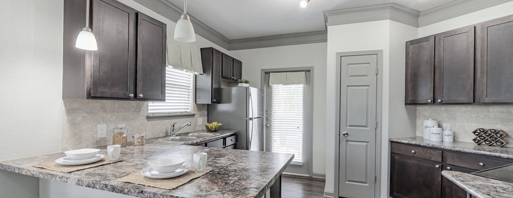 a kitchen with a marble counter top and a stainless steel refrigerator at Century HomePlace, Prattville, AL