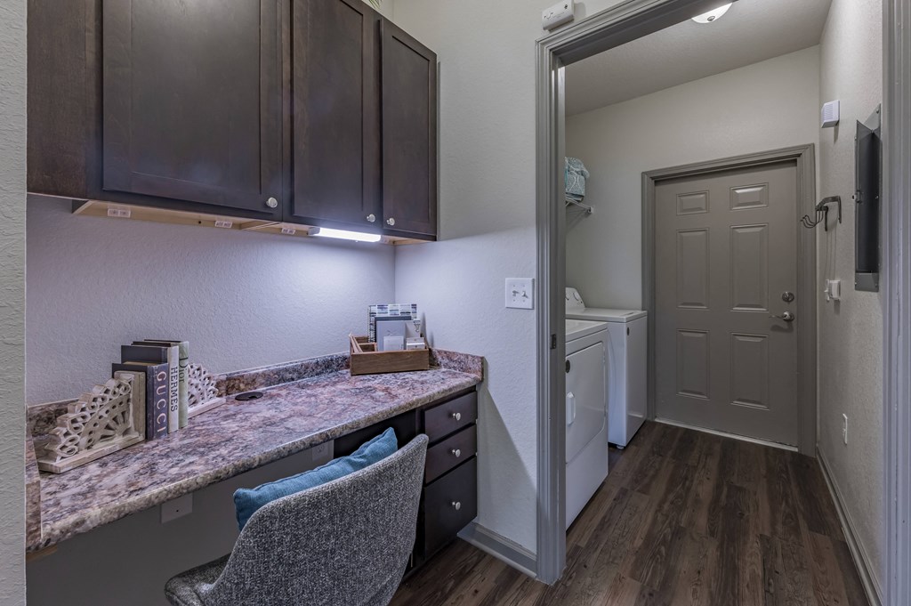 a kitchen with a counter top and a door to a laundry room at Century HomePlace, Prattville
