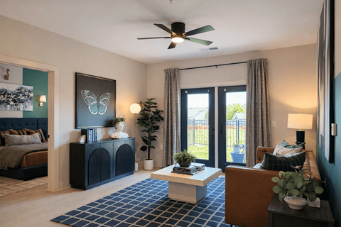 A living room with a ceiling fan and a large painting on the wall.
