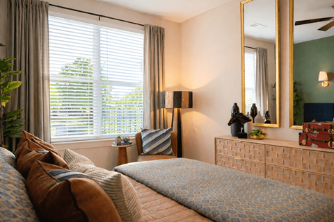 A bedroom with a large bed and a mirror on the wall.