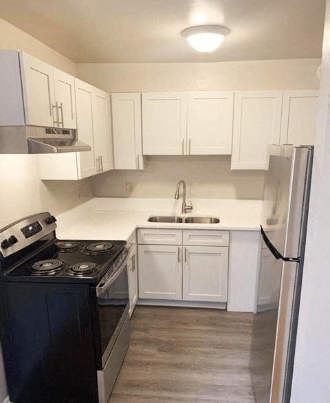 a kitchen with white cabinets and a stove and a refrigerator