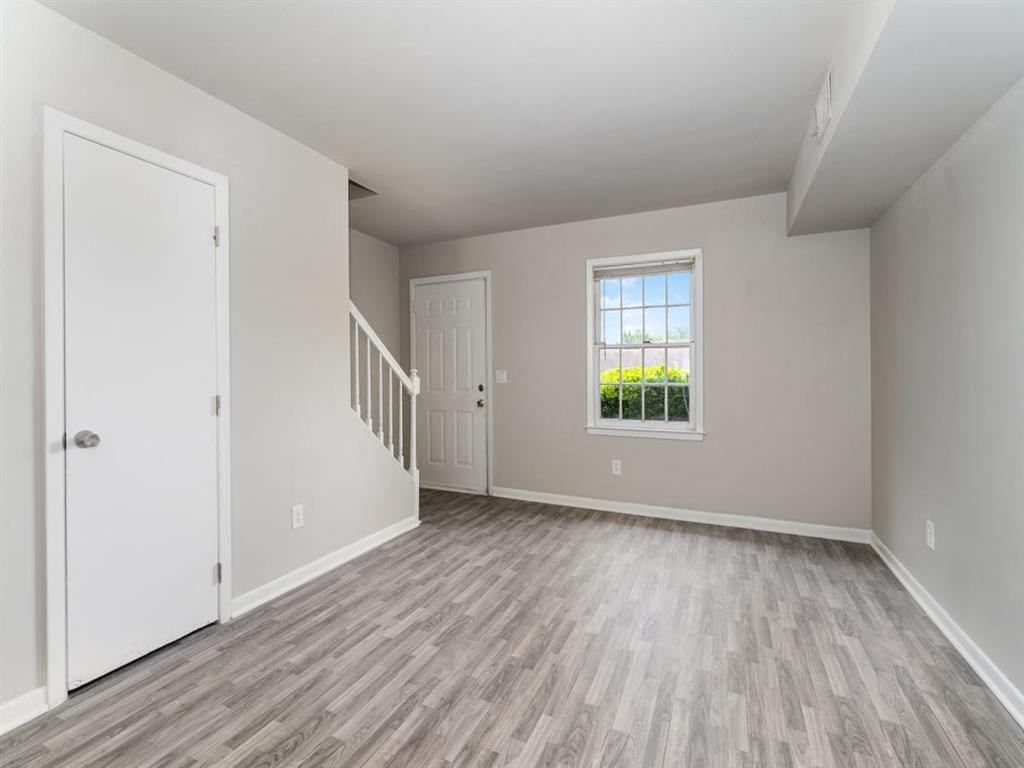 an empty living room with a staircase and a window at Four Seasons Villas, North Carolina, 27406