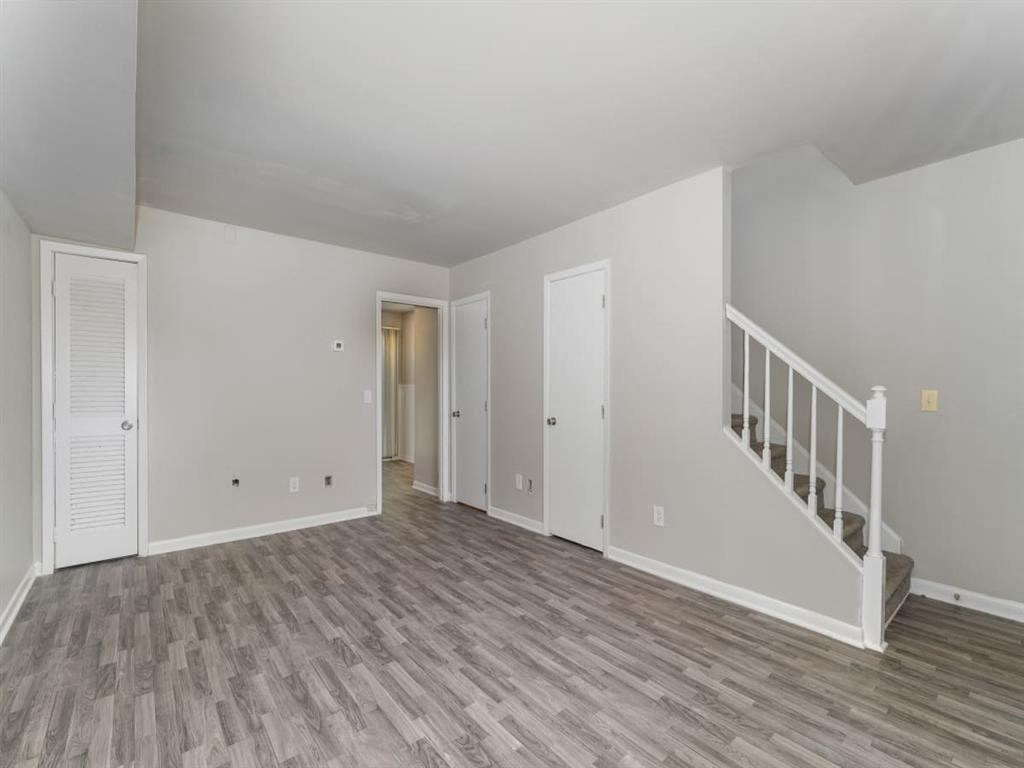 the living room and staircase of an empty house with wood flooring at Four Seasons Villas, North Carolina