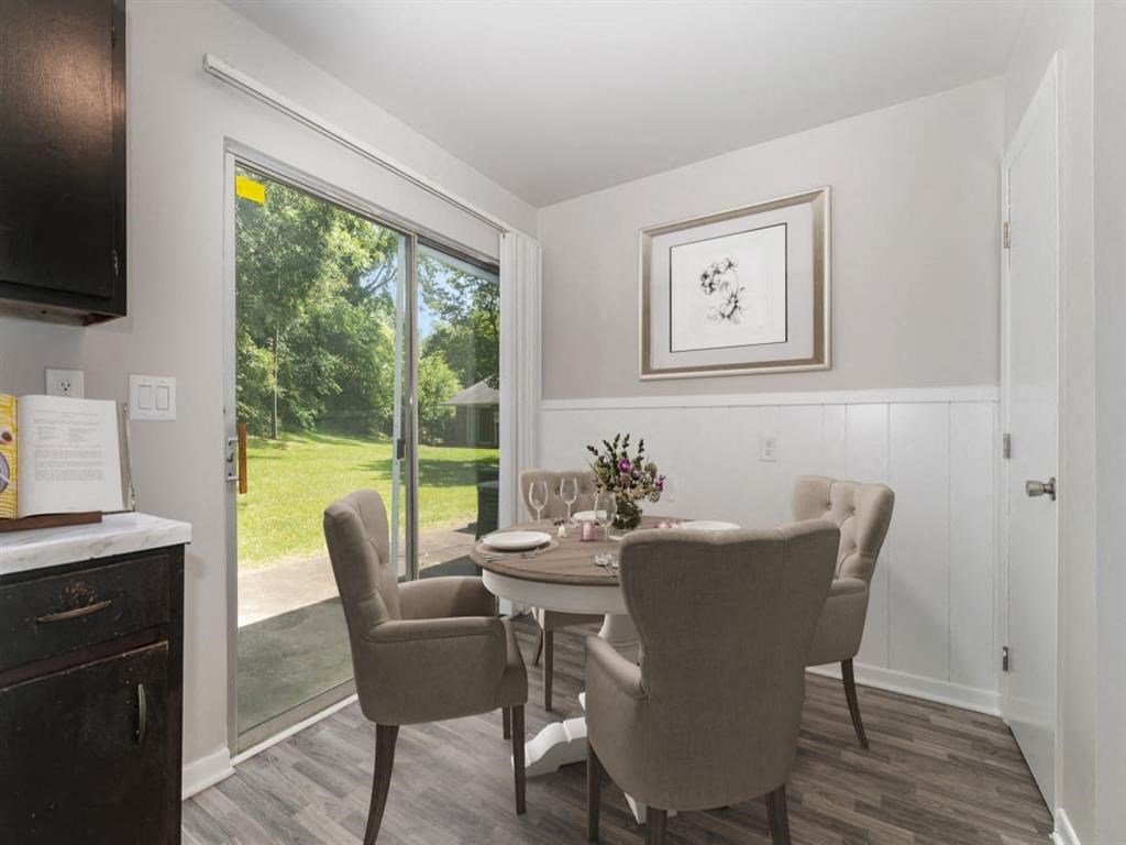 a dining room with a table and chairs and a sliding glass door at Four Seasons Villas, Greensboro, 27406