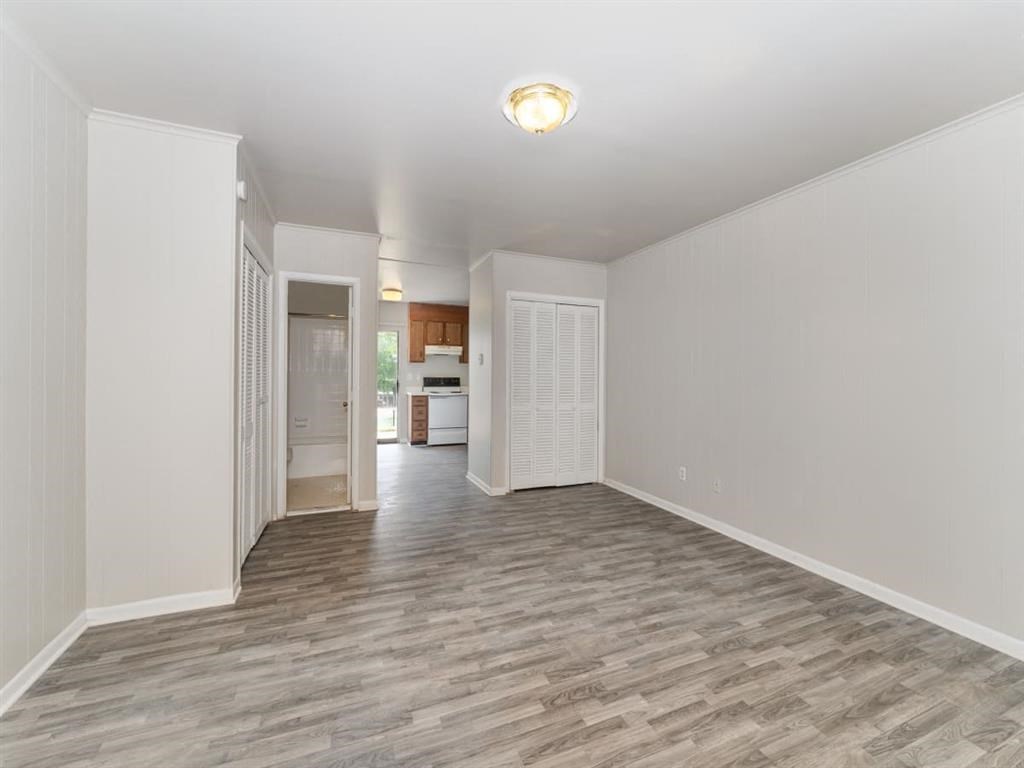 an empty living room with white walls and wood floors at Four Seasons Villas, Greensboro, NC 27406