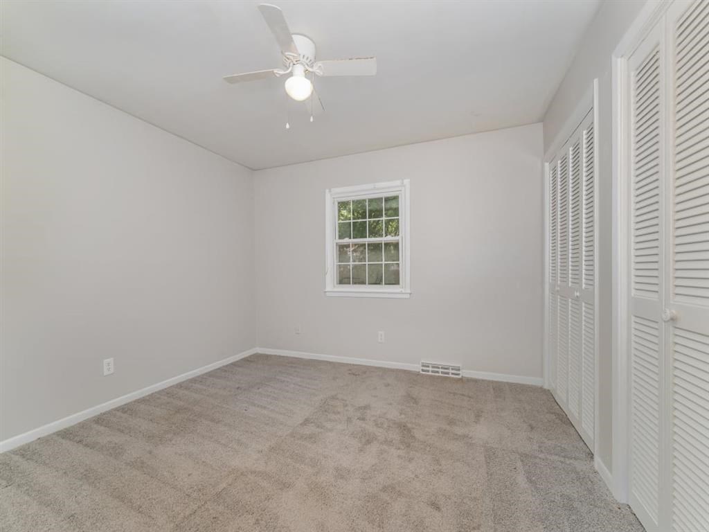 an empty living room with a ceiling fan and a closet at Four Seasons Villas, North Carolina