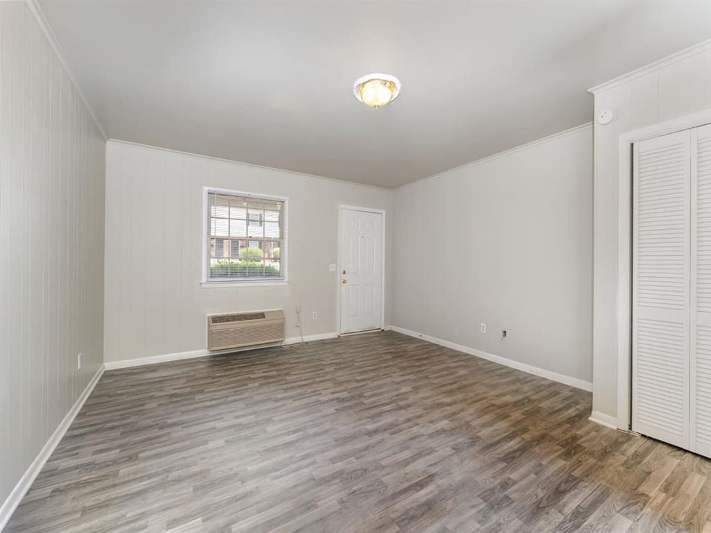 an empty living room with wood flooring and a window at Four Seasons Villas, Greensboro, NC