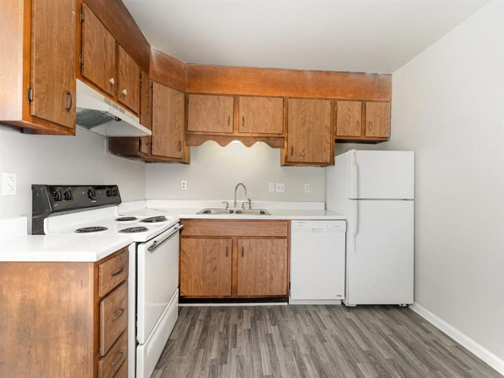 a kitchen with white appliances and wooden cabinets at Four Seasons Villas, North Carolina, 27406