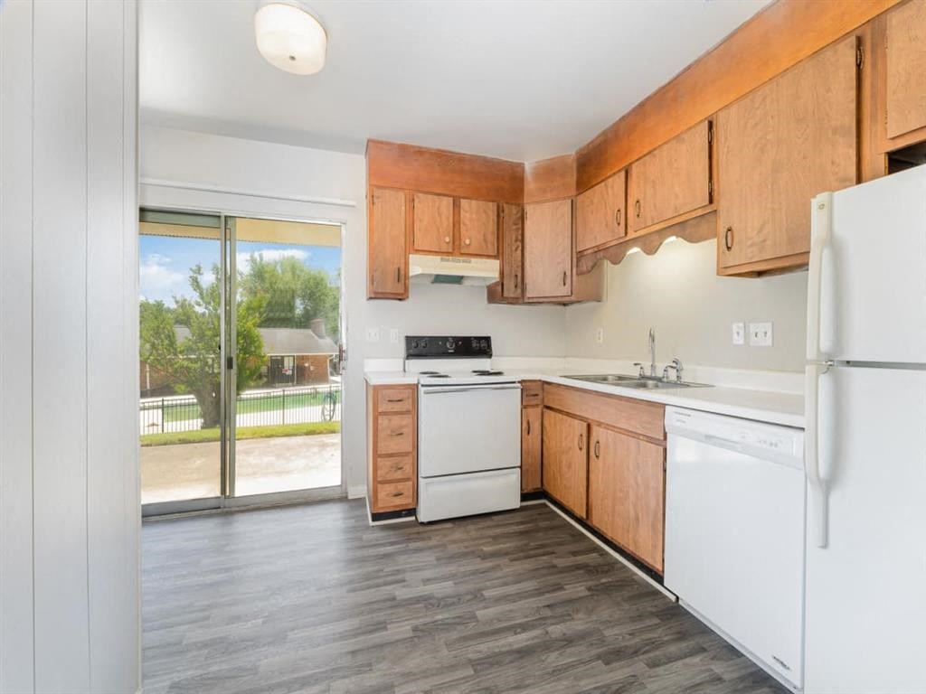 a kitchen with white appliances and wooden cabinets at Four Seasons Villas, Greensboro North Carolina