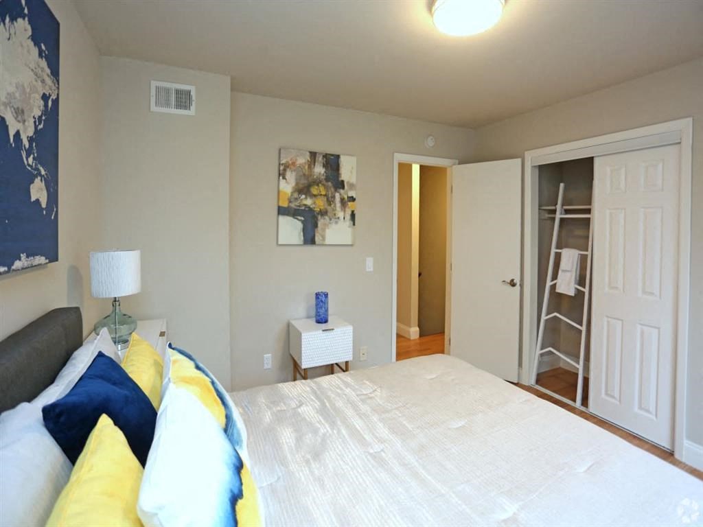 a bedroom with a large bed and a closet at Four Seasons Villas, Greensboro