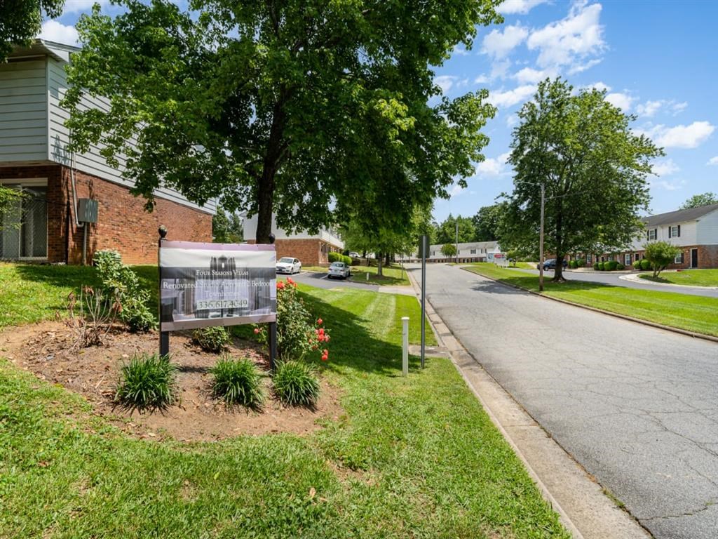 a sign sits in the grass next to a street at Four Seasons Villas, Greensboro, NC