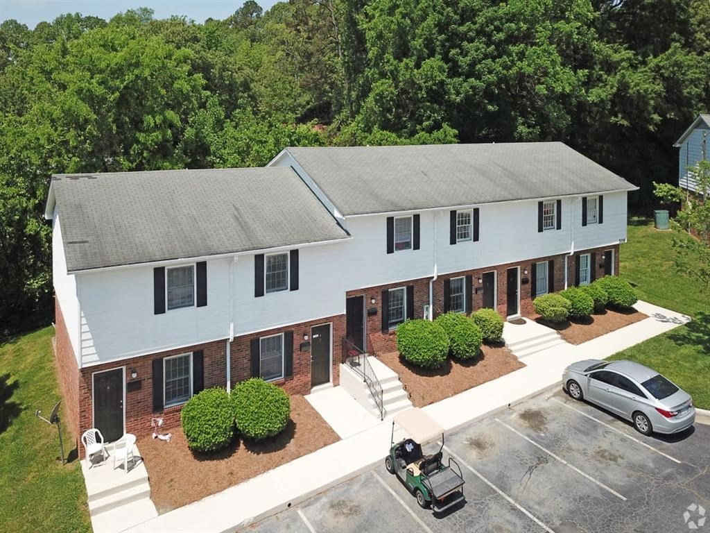 an aerial view of a white house with a yard and a vehicle parked in front at Four Seasons Villas, Greensboro, 27406