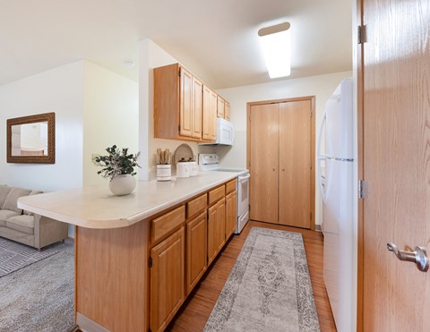 A kitchen with wooden cabinets and a white countertop.