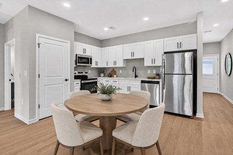 A modern kitchen with a round table and chairs.