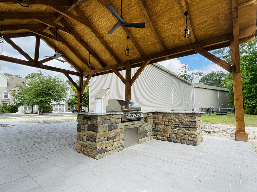an outdoor kitchen with a grill and a fireplace