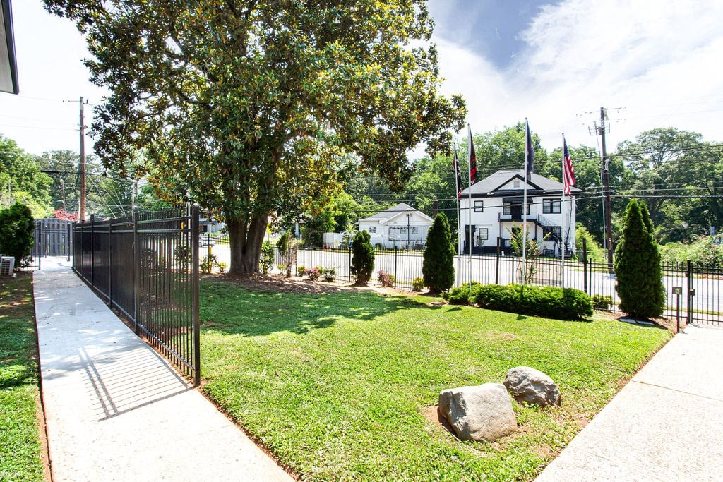 a yard with a tree and a black fence  at The Oasis on Cascade, Atlanta, GA, 30310