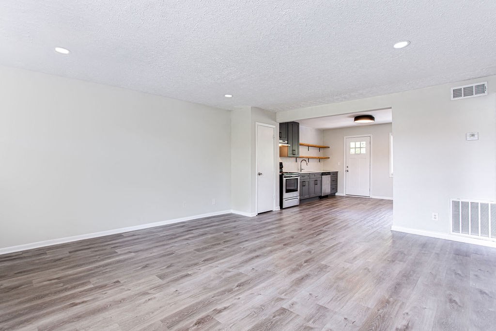 a spacious living room with a kitchen in the background  at The Oasis on Cascade, Atlanta, 30310