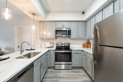 A modern kitchen with stainless steel appliances and a white countertop.