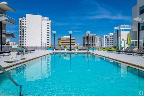 A large swimming pool in a city setting with buildings in the background.