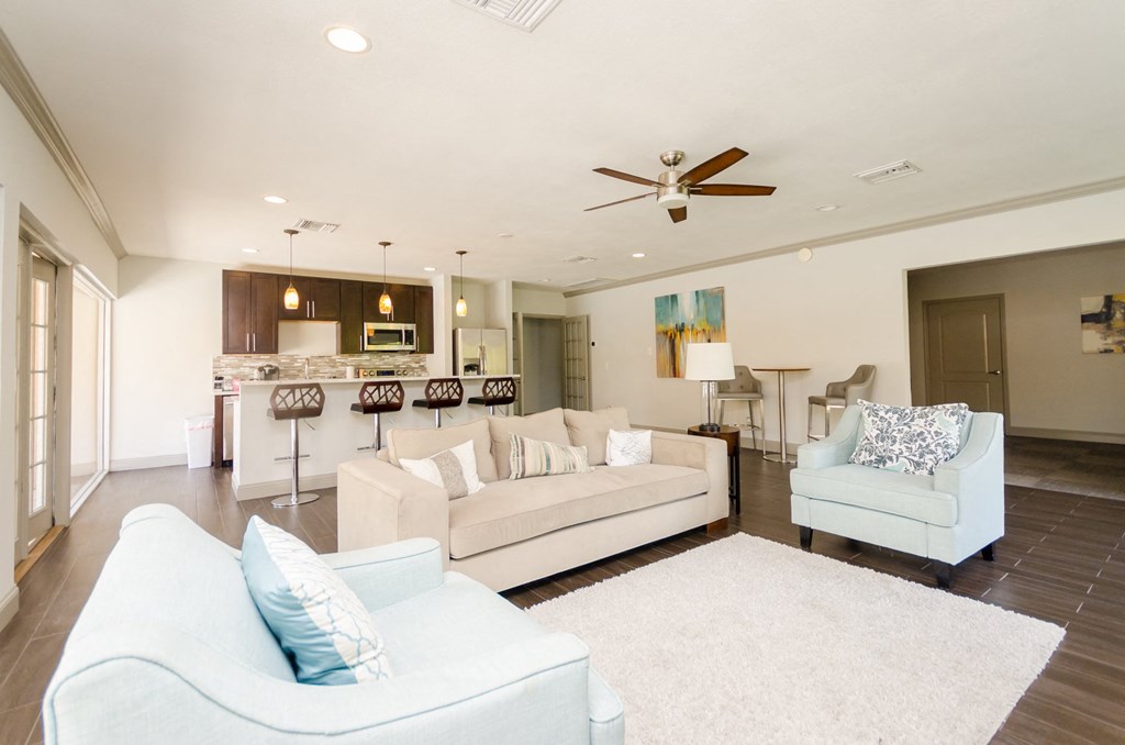 a living room with couches and chairs and a kitchen