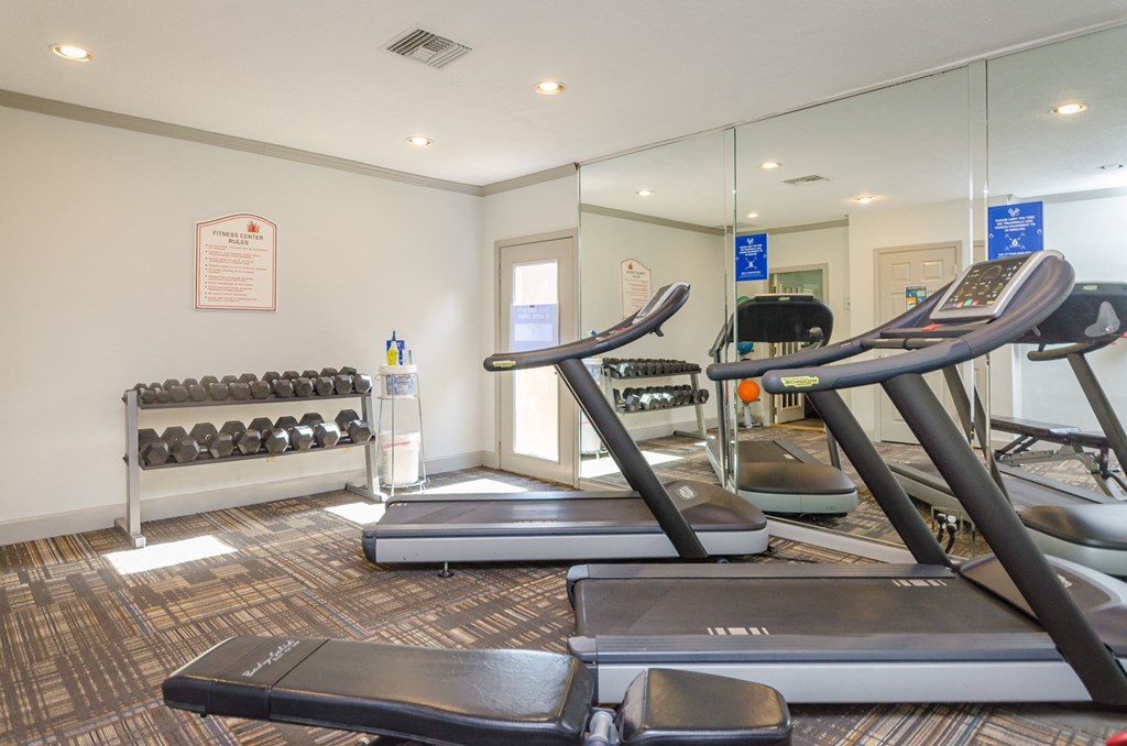 a gym with treadmills and other exercise equipment at the enclave at university crossings