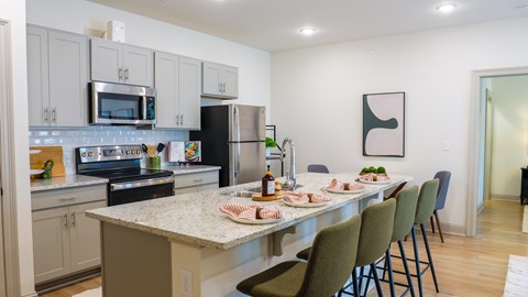 A kitchen with a table and chairs set for a meal.