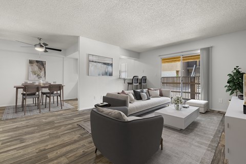 A living room with a grey couch and a wooden floor.
