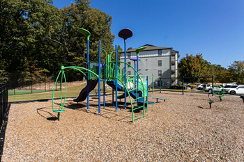 a playground at a park with a building in the background at Peaks at Gainesville, Gainesville, GA, 30507