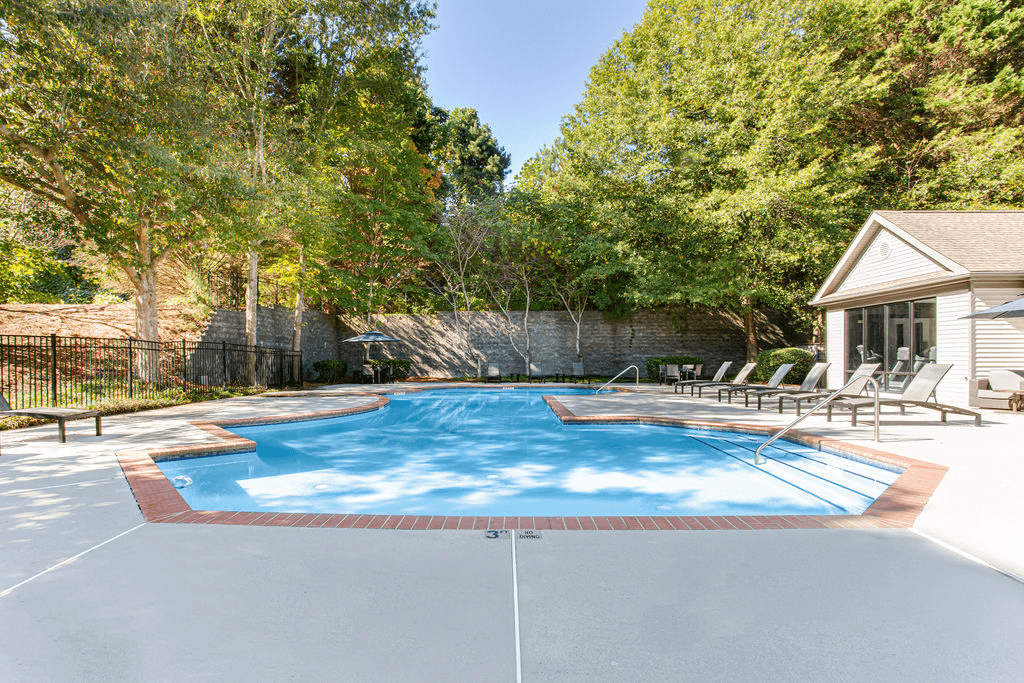 a pool with chairs and a house in the background  at Peaks at Gainesville, Gainesville, GA