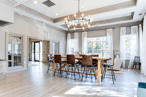 a dining room with a wooden table and chairs and a chandelier  at Peaks at Gainesville, Gainesville, GA