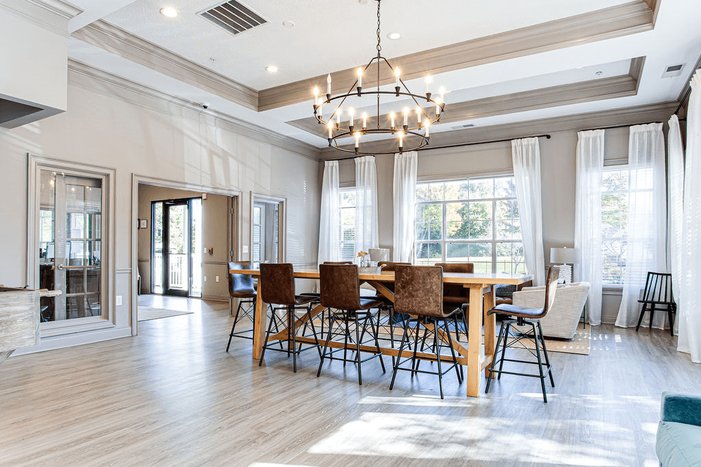 a dining room with a wooden table and chairs and a chandelier a dining room with a wooden table and chairs and a chandelier at Peaks at Gainesville, Gainesville, GA