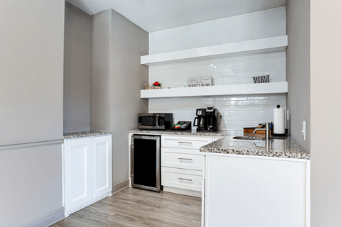 a kitchen with white cabinets and counter tops and a sink
