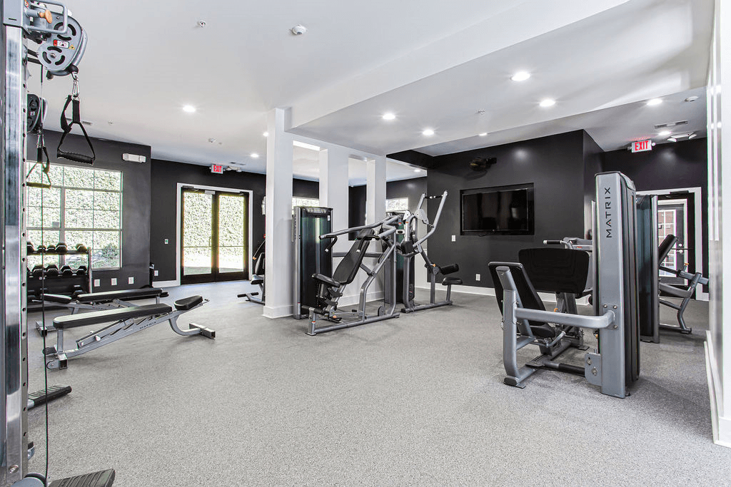 a gym with weights and a tv on the wall  at Peaks at Gainesville, Gainesville, GA, 30507