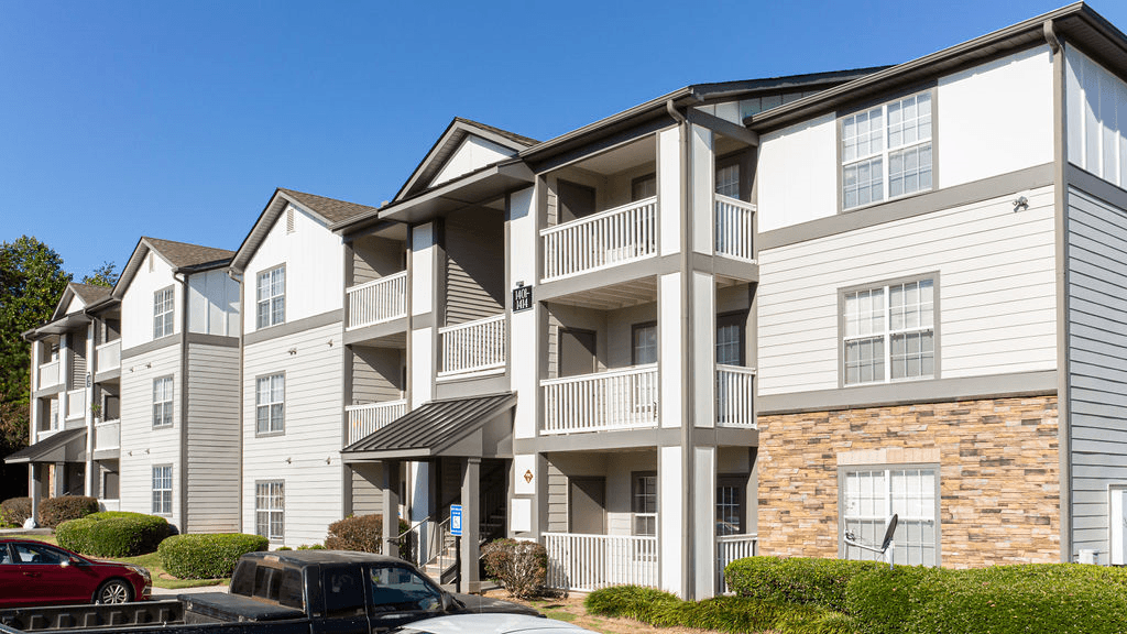 a row of apartments with balconies and cars parked in front  at Peaks at Gainesville, Gainesville, Georgia